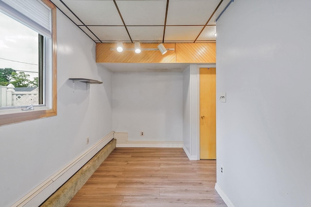 8 Adolphi Pl, Ronkonkoma, NY 11779 - basement featuring a baseboard heating unit, light wood-type flooring, baseboards, and a drop ceiling
