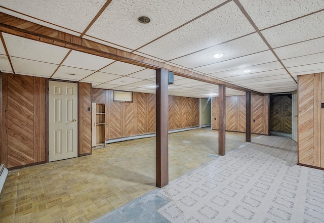 8 Adolphi Pl, Ronkonkoma, NY 11779 - finished basement featuring wooden walls, a drop ceiling, a baseboard heating unit, and baseboard heating