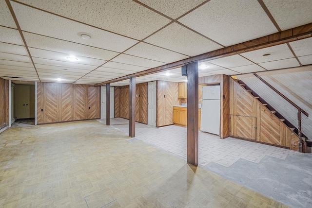 8 Adolphi Pl, Ronkonkoma, NY 11779 - finished basement with freestanding refrigerator, wood walls, a drop ceiling, and light flooring