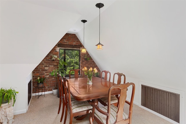 6 Davis Ave Unit A42, Rye, NY 10580 - dining area with radiator heating unit, vaulted ceiling, baseboards, light carpet, and brick wall