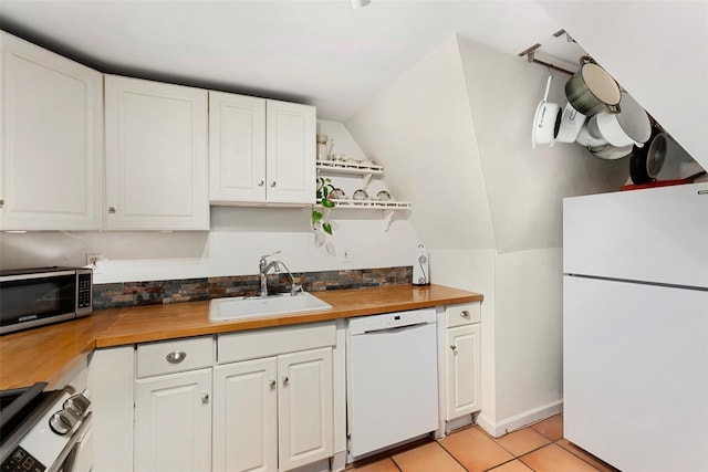 6 Davis Ave Unit A42, Rye, NY 10580 - kitchen featuring white appliances, a sink, wooden counters, lofted ceiling, and white cabinetry