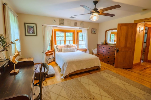470 Winding Hill Rd, Montgomery, NY 12549 - bedroom featuring a baseboard heating unit, light wood-style floors, ceiling fan, and baseboards