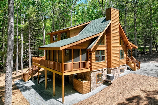 57 Zane Grey Way, Barryville, NY 12719 - view of front facade featuring a shingled roof, log siding, stairs, a sunroom, and a chimney