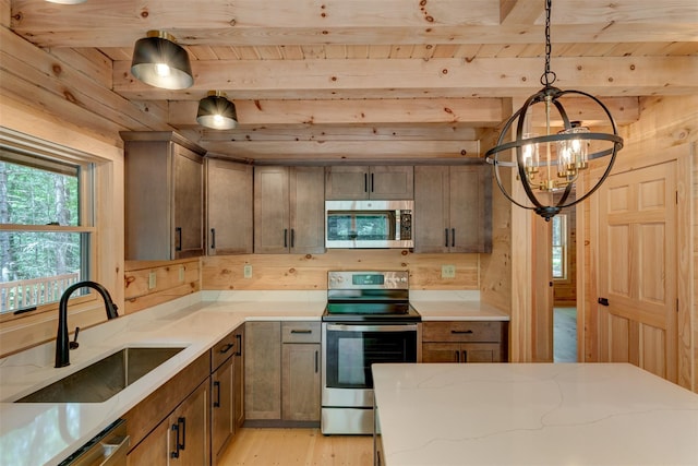 57 Zane Grey Way, Barryville, NY 12719 - kitchen featuring appliances with stainless steel finishes, a sink, a chandelier, light wood finished floors, and light stone counters