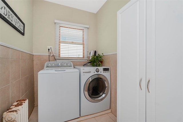 39 Summit Ave, Staten Island, NY 10306 - washroom featuring radiator heating unit, tile walls, washing machine and dryer, wainscoting, and light tile patterned flooring