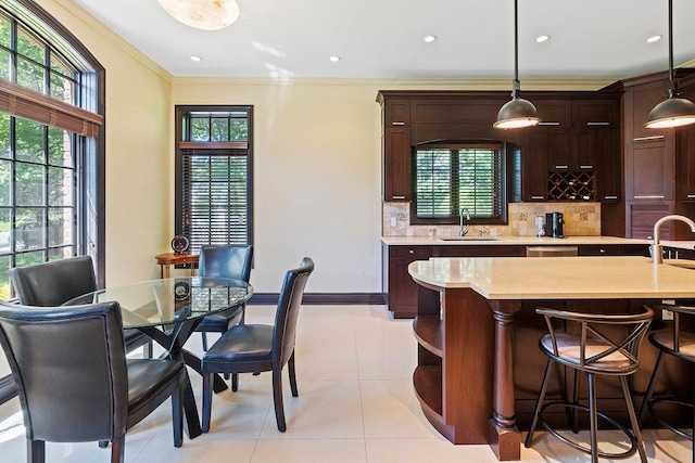 23 Tanners Rd, Great Neck, NY 11020 - kitchen featuring a sink, light countertops, backsplash, ornamental molding, and pendant lighting