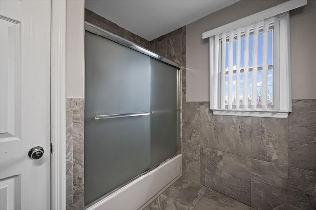 15 Salem Rd, Hicksville, NY 11801 - bathroom featuring marble look tiles, tile walls, shower / bath combination with glass door, and a wainscoted wall
