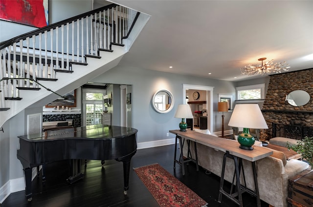 87 River Rd, Nyack, NY 10960 - living area with a fireplace, baseboards, stairs, a chandelier, and wood finished floors