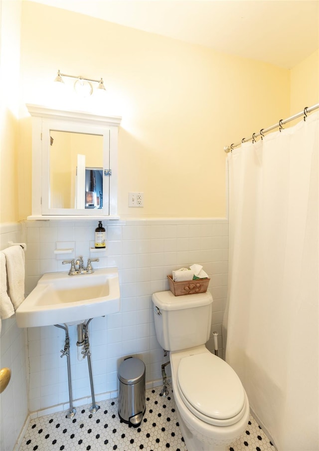 87 River Rd, Nyack, NY 10960 - bathroom featuring toilet, a wainscoted wall, tile walls, a sink, and a shower with shower curtain