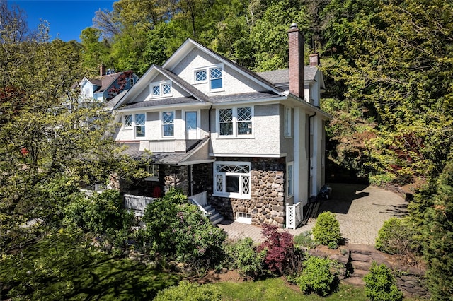 87 River Rd, Nyack, NY 10960 - view of front of house featuring stone siding, a chimney, and stucco siding