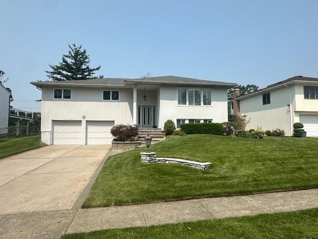 442 Old Courthouse Rd, Manhasset Hills, NY 11040 - raised ranch with a garage, concrete driveway, and a front lawn