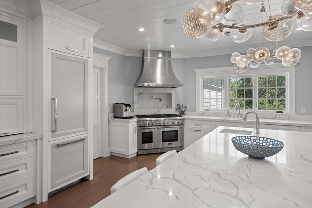 8 E Huxley Dr, Lloyd Harbor, NY 11743 - kitchen with range with two ovens, wall chimney range hood, a chandelier, ornamental molding, and dark wood finished floors