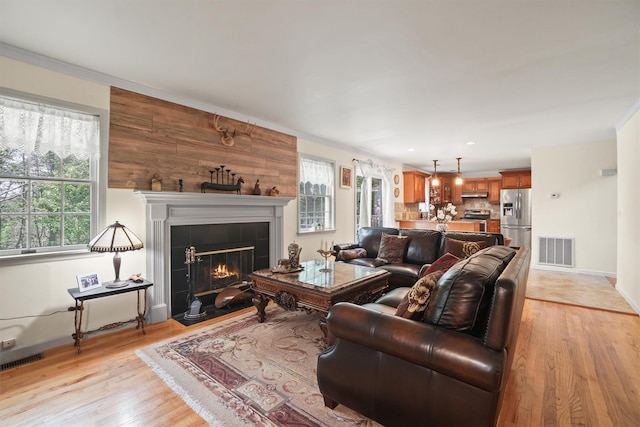 57 Wilner Rd, Somers, NY 10589 - living room featuring a tile fireplace, plenty of natural light, light wood-style flooring, baseboards, and ornamental molding