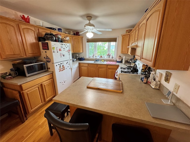 1009 Ethan Allen Dr Unit 1009, New Windsor, NY 12553 - kitchen with white appliances, a ceiling fan, a kitchen bar, a peninsula, and light countertops