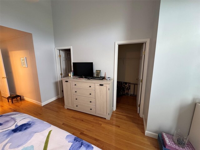 1009 Ethan Allen Dr Unit 1009, New Windsor, NY 12553 - bedroom featuring light wood-style floors, a spacious closet, baseboards, a closet, and a towering ceiling