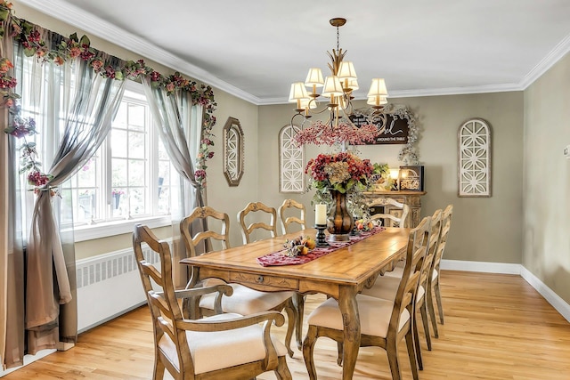 258 Timberpoint Rd, East Islip, NY 11730 - dining area with light wood-style flooring, a chandelier, radiator heating unit, ornamental molding, and baseboards