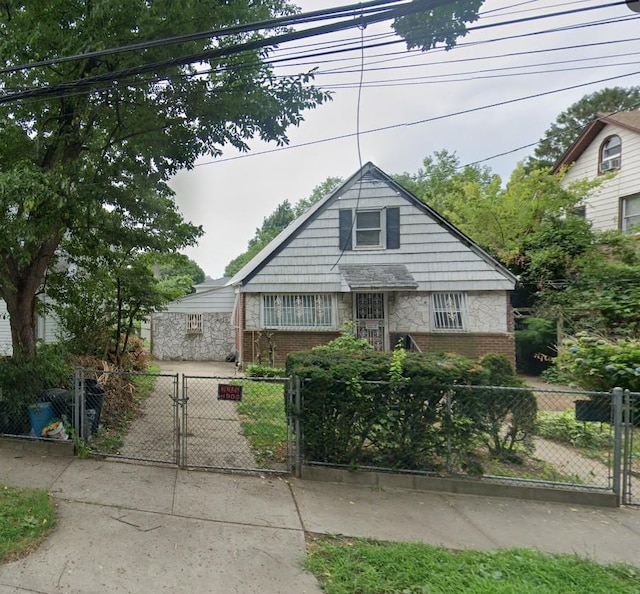89-48 196th St, Jamaica, NY 11423 - view of front of home featuring brick siding and a gate