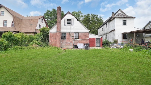 89-48 196th St, Jamaica, NY 11423 - rear view of house featuring brick siding, a chimney, and a yard