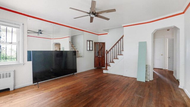 89-48 196th St, Jamaica, NY 11423 - unfurnished living room with radiator, a ceiling fan, hardwood / wood-style floors, stairs, and crown molding