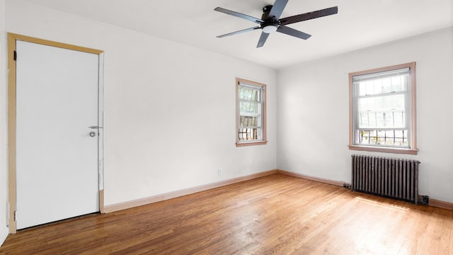 89-48 196th St, Jamaica, NY 11423 - spare room featuring radiator heating unit, wood finished floors, and a ceiling fan