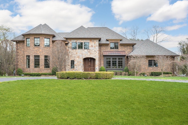 24 The Pnes, Old Westbury, NY 11568 - french provincial home featuring a front yard, stone siding, and brick siding