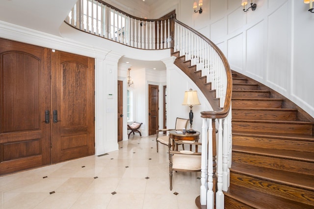 24 The Pnes, Old Westbury, NY 11568 - entrance foyer with stairs, ornamental molding, a towering ceiling, and a decorative wall