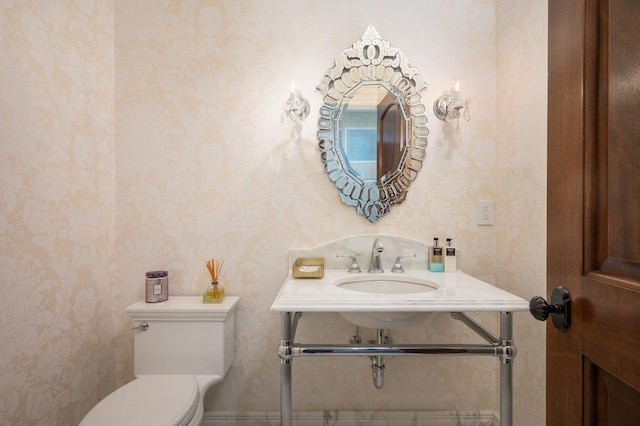 24 The Pnes, Old Westbury, NY 11568 - bathroom featuring wallpapered walls, toilet, and a sink