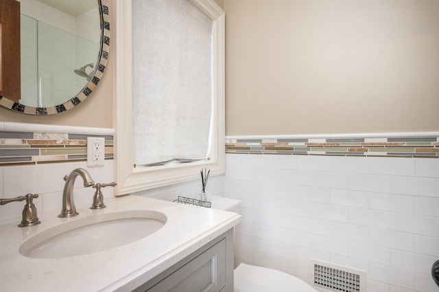 24 The Pnes, Old Westbury, NY 11568 - bathroom with toilet, vanity, tile walls, and wainscoting