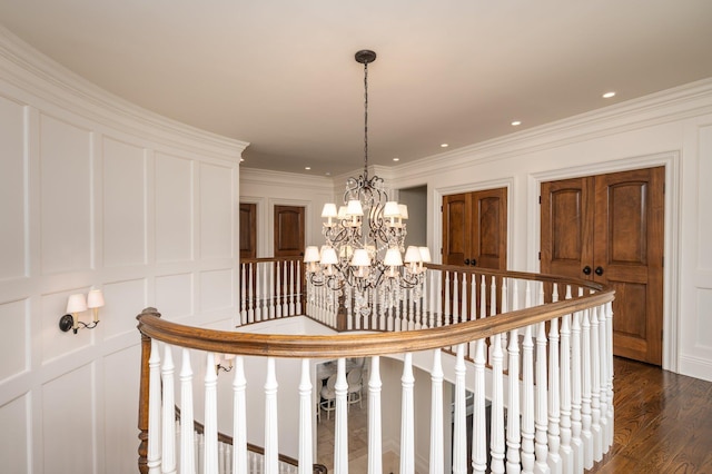 24 The Pnes, Old Westbury, NY 11568 - stairway featuring a chandelier, a decorative wall, wood finished floors, and crown molding