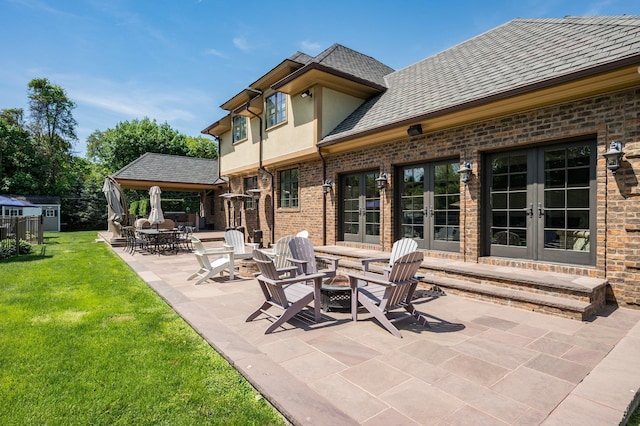24 The Pnes, Old Westbury, NY 11568 - view of patio featuring french doors and a fire pit