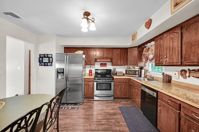 10 Catawba Dr, West Nyack, NY 10994 - kitchen featuring appliances with stainless steel finishes, dark wood-style floors, light countertops, a sink, and brown cabinetry