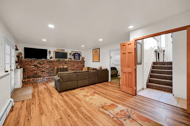 10 Catawba Dr, West Nyack, NY 10994 - living room with baseboard heating, light wood finished floors, stairs, recessed lighting, and brick wall