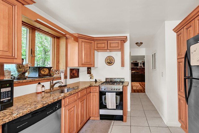 10 Catawba Dr, West Nyack, NY 10994 - kitchen featuring stainless steel dishwasher, gas range oven, light stone countertops, a sink, and light tile patterned floors