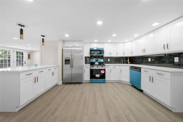 28 Snowberry Ln, Islandia, NY 11749 - kitchen with appliances with stainless steel finishes, light wood finished floors, a peninsula, tasteful backsplash, and white cabinetry