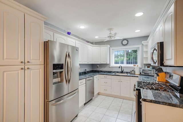 74 Gauguin Ct Unit 74, Middle Island, NY 11953 - kitchen featuring stainless steel appliances, a sink, light tile patterned flooring, dark stone countertops, and a ceiling fan