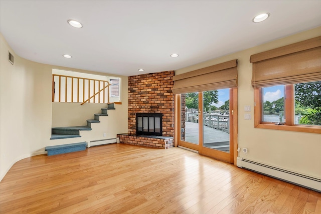2917 Frankel Blvd, Merrick, NY 11566 - unfurnished living room with a baseboard radiator, wood finished floors, recessed lighting, a brick fireplace, and stairway