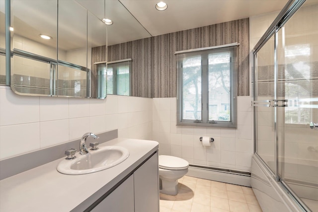 2917 Frankel Blvd, Merrick, NY 11566 - bathroom with baseboard heating, tile walls, healthy amount of natural light, toilet, and bath / shower combo with glass door