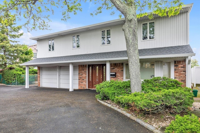 2917 Frankel Blvd, Merrick, NY 11566 - view of front facade with asphalt driveway, brick siding, a shingled roof, and a garage