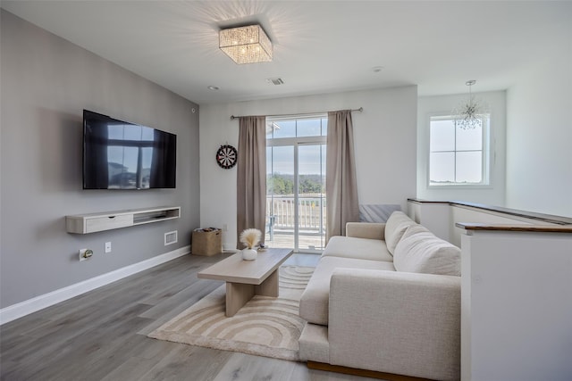 12 Grace Hall Ln, Yaphank, NY 11980 - living area featuring wood finished floors, a chandelier, and baseboards