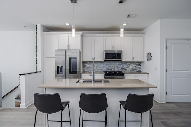 12 Grace Hall Ln, Yaphank, NY 11980 - kitchen featuring appliances with stainless steel finishes, backsplash, a breakfast bar, a sink, and recessed lighting