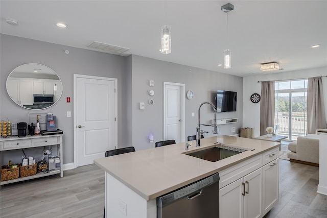 12 Grace Hall Ln, Yaphank, NY 11980 - kitchen with a sink, appliances with stainless steel finishes, open floor plan, light wood-type flooring, and white cabinetry