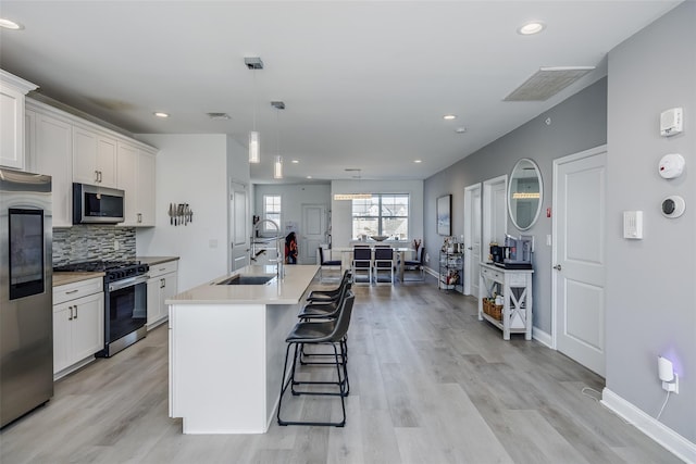 12 Grace Hall Ln, Yaphank, NY 11980 - kitchen featuring stainless steel appliances, a sink, light wood-type flooring, white cabinetry, and recessed lighting