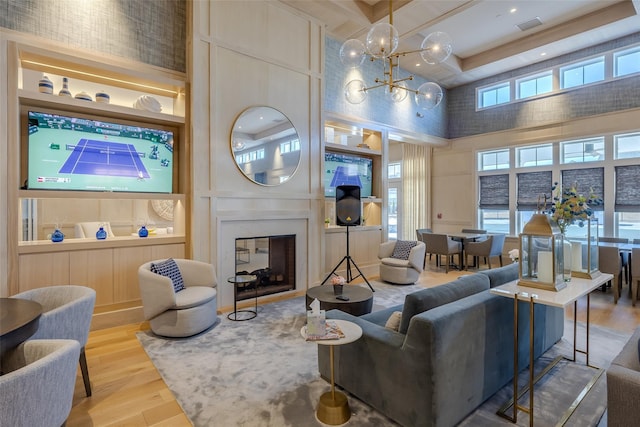 12 Grace Hall Ln, Yaphank, NY 11980 - living area featuring a high ceiling, wood finished floors, coffered ceiling, a chandelier, and beamed ceiling