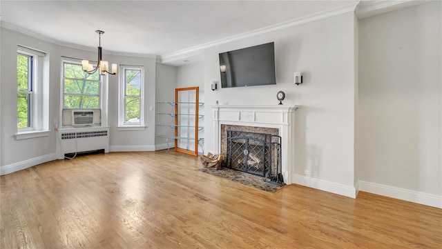 8 Barstow Rd Unit 2G, Great Neck, NY 11021 - unfurnished living room featuring radiator, crown molding, a fireplace, wood finished floors, and baseboards