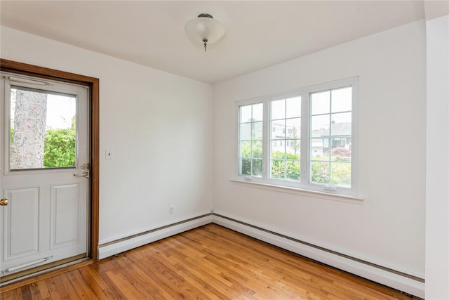 233 Violet St, Massapequa Park, NY 11762 - spare room with healthy amount of natural light, light wood-style floors, and a baseboard heating unit