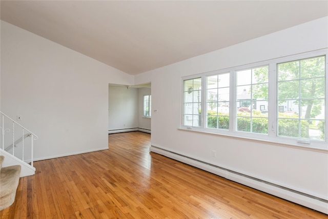 233 Violet St, Massapequa Park, NY 11762 - spare room with baseboard heating, light wood-style floors, stairway, vaulted ceiling, and baseboards