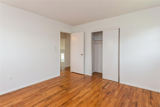 233 Violet St, Massapequa Park, NY 11762 - unfurnished bedroom with light wood-style floors, a closet, and baseboards