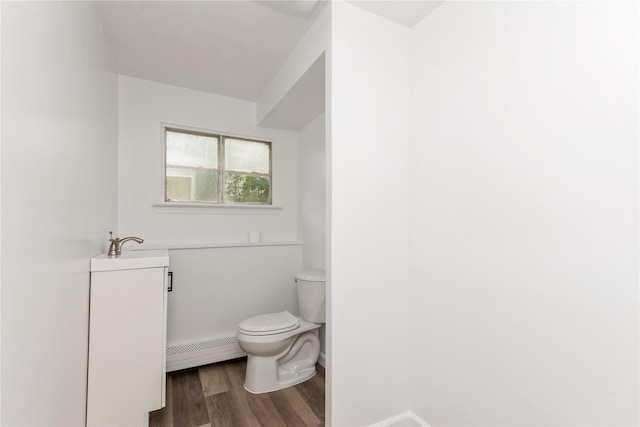 233 Violet St, Massapequa Park, NY 11762 - half bathroom with a baseboard radiator, toilet, vanity, wood finished floors, and baseboards