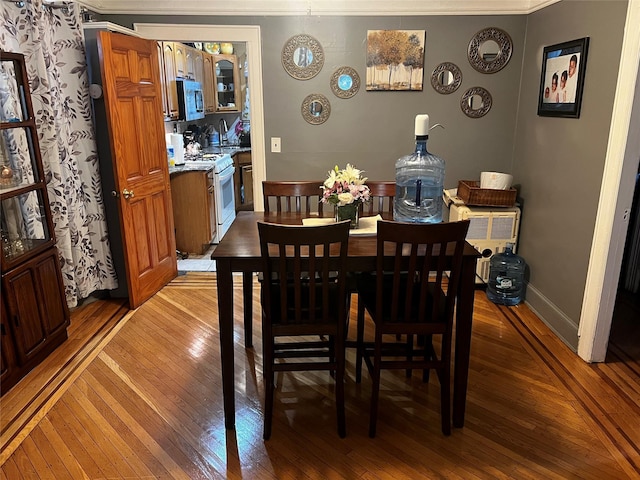 11120 139th St, Jamaica, NY 11435 - dining room with light wood finished floors, baseboards, and crown molding