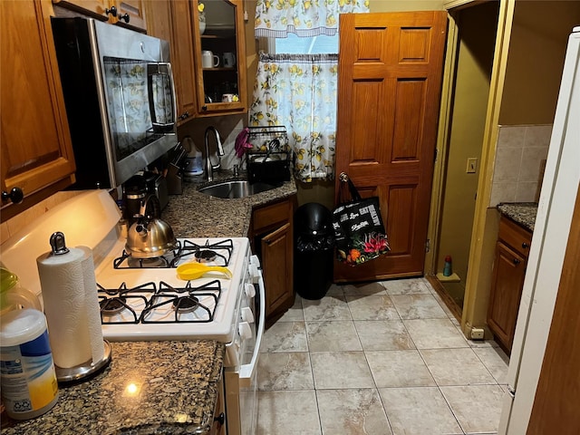 11120 139th St, Jamaica, NY 11435 - kitchen with stainless steel microwave, a sink, gas range gas stove, glass insert cabinets, and brown cabinetry